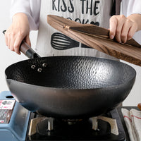 Cooking in the Hammerwok on a gas burner, wooden lid in hand